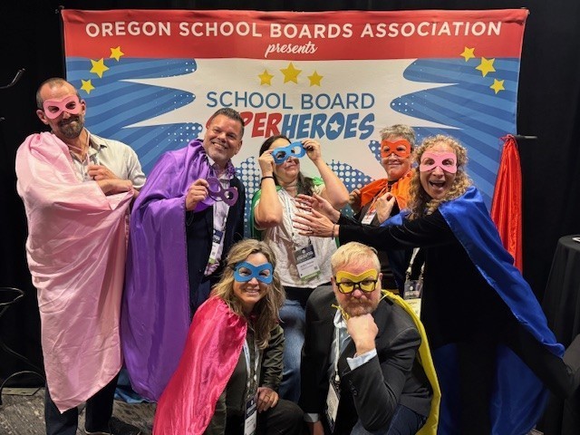 Board members dressed in superhero capes 