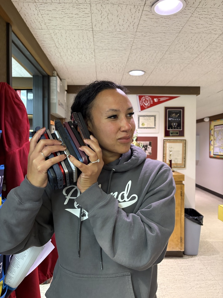 Assistant Principal Becca holding a stack of cell phones