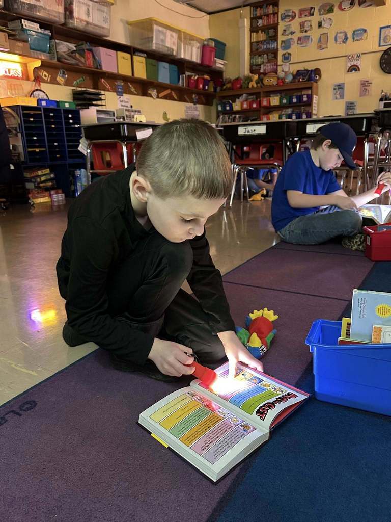Students reading with flashlights