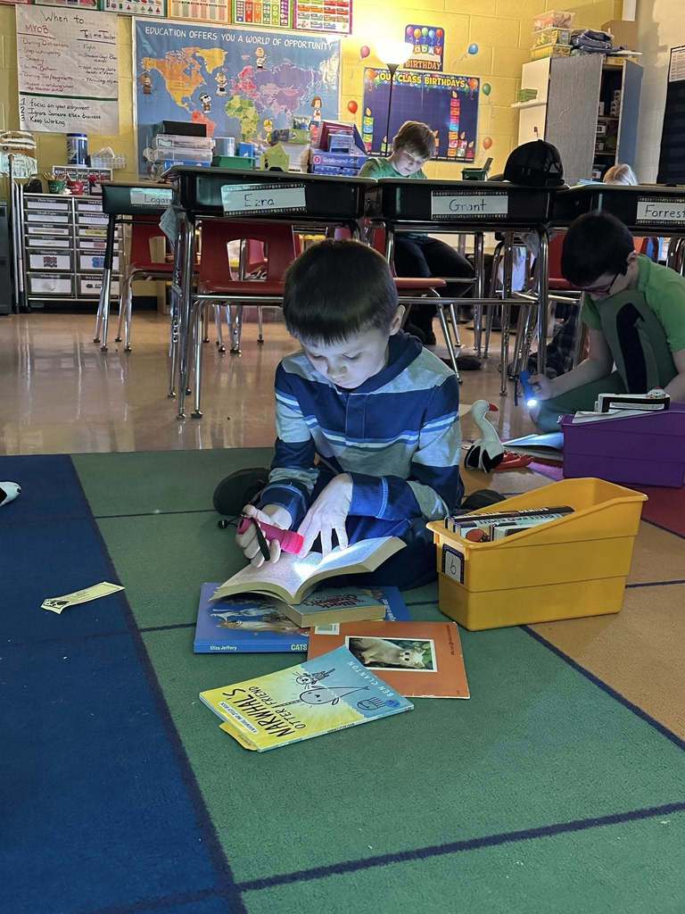 Students reading with flashlights