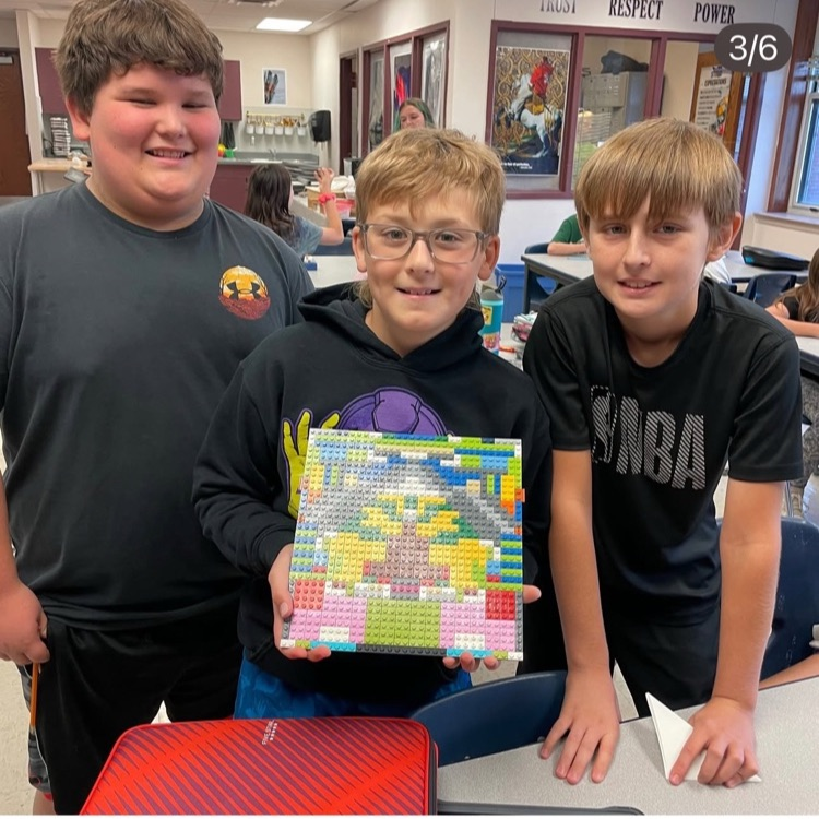 3 students holding an art project