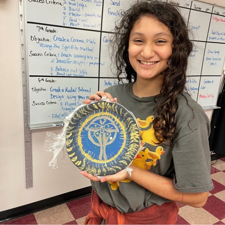 student holding art project