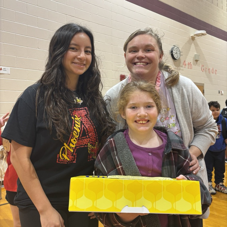 three people with a box of donuts
