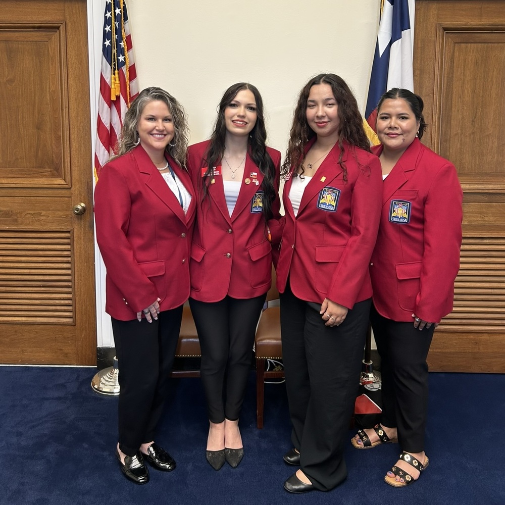 Photo of two adult women and two teenage girls in red USAA jackets, smiling