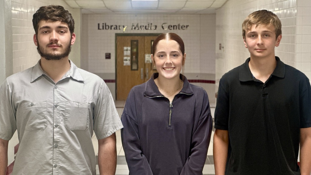 Athens High School seniors Gage Stasko, Chloe Coker, and Gaden Riquelme stand in a hallway in front of the Library Media Center. All three students were recognized by the College Board National Recognition Program for academic achievement.