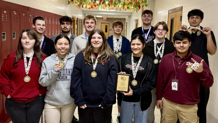 A group of students, girls and boys, dressed casually in some cases and more nicely and others, display the medals around their necks