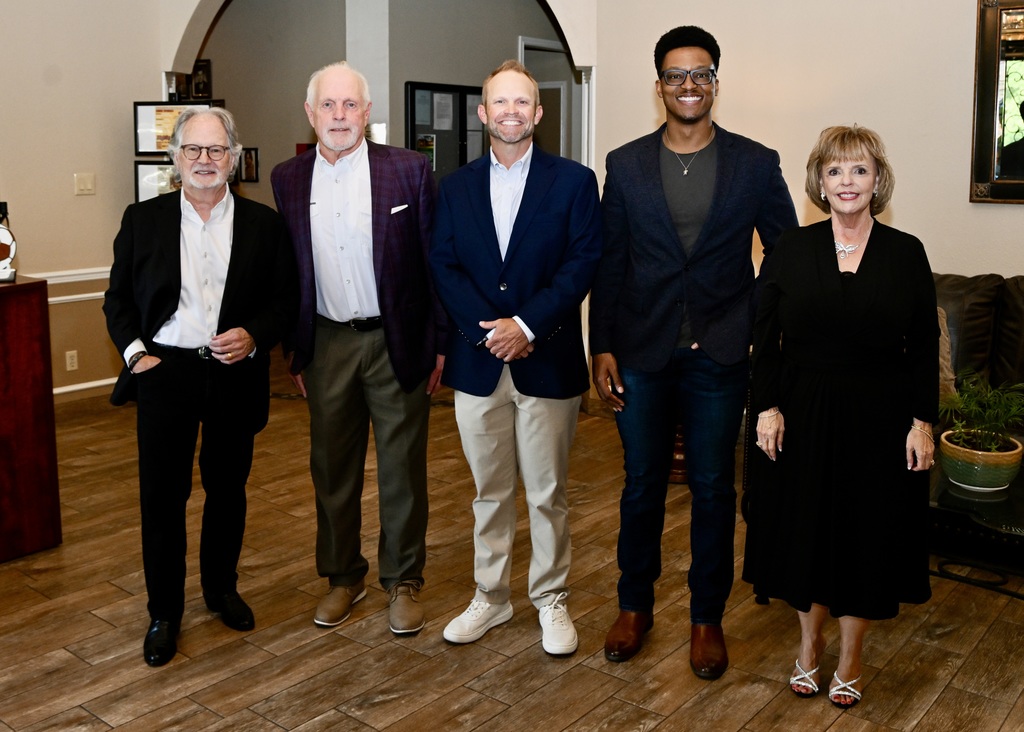 Five people pose together at the Athens ISD Distinguished Alumni & Athletic Hall of Fame event. From left are Dan Dwelle, Tommy Frizzell, Seth Murphy, Quinton Johnson and Superintendent Sims, standing side by side in formal attire in a banquet room with wood floors and arched doorways.