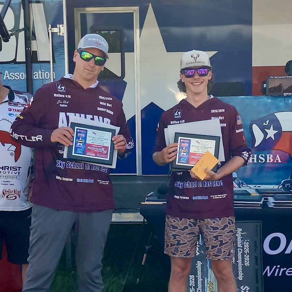 Two bass fishing team members stand in front of a Texas-themed backdrop, smiling and holding plaques after a tournament; both wear maroon team jerseys and sunglasses, with one holding an envelope, celebrating their 9th-place regional finish and state qualification.