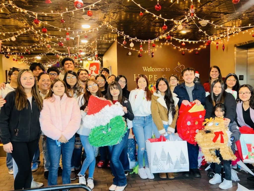 students smile with pinatas at christmas time
