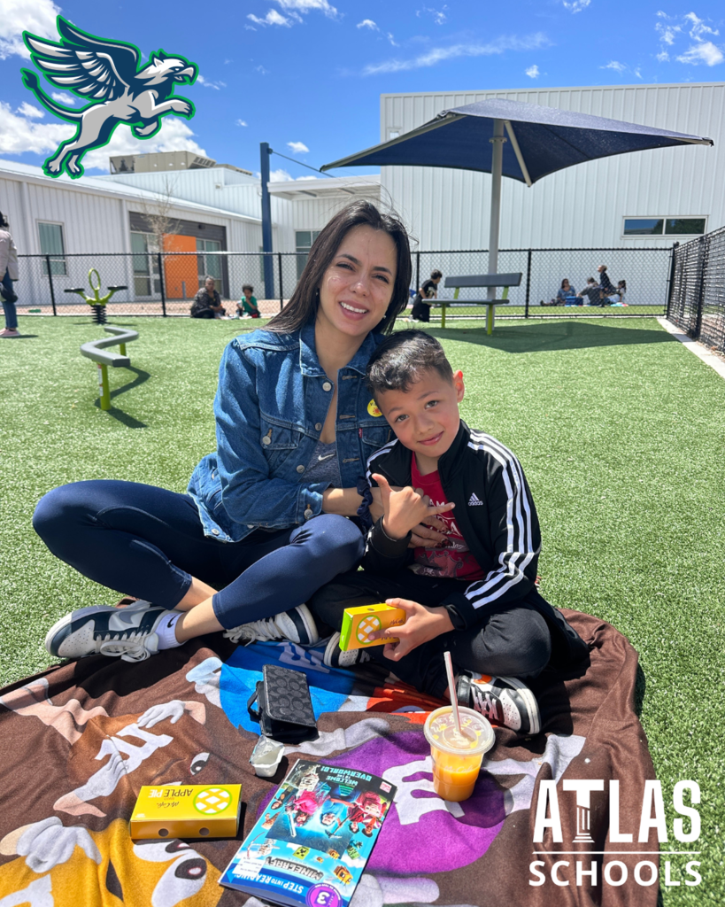 mom and student smile while eating lunch and reading books outside