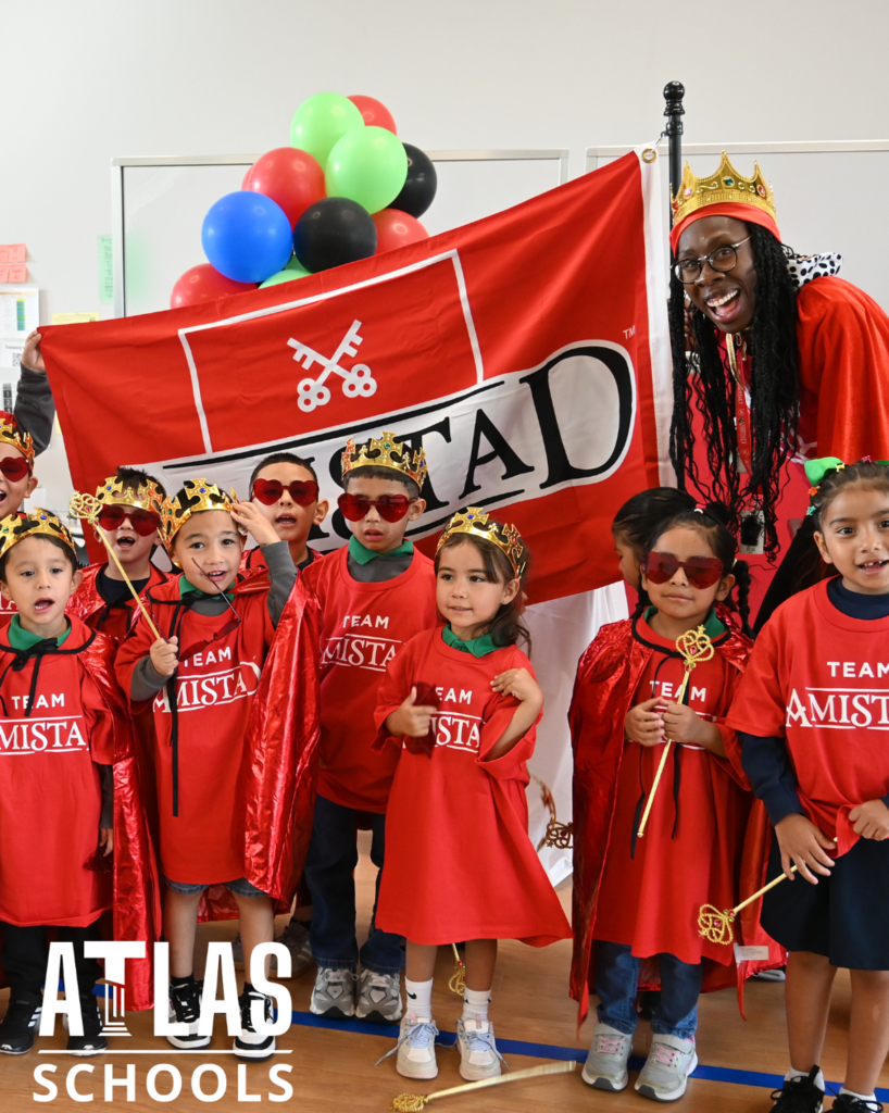 students smile with crowns, flags and wands
