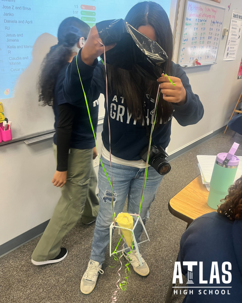 student holds egg with parachute