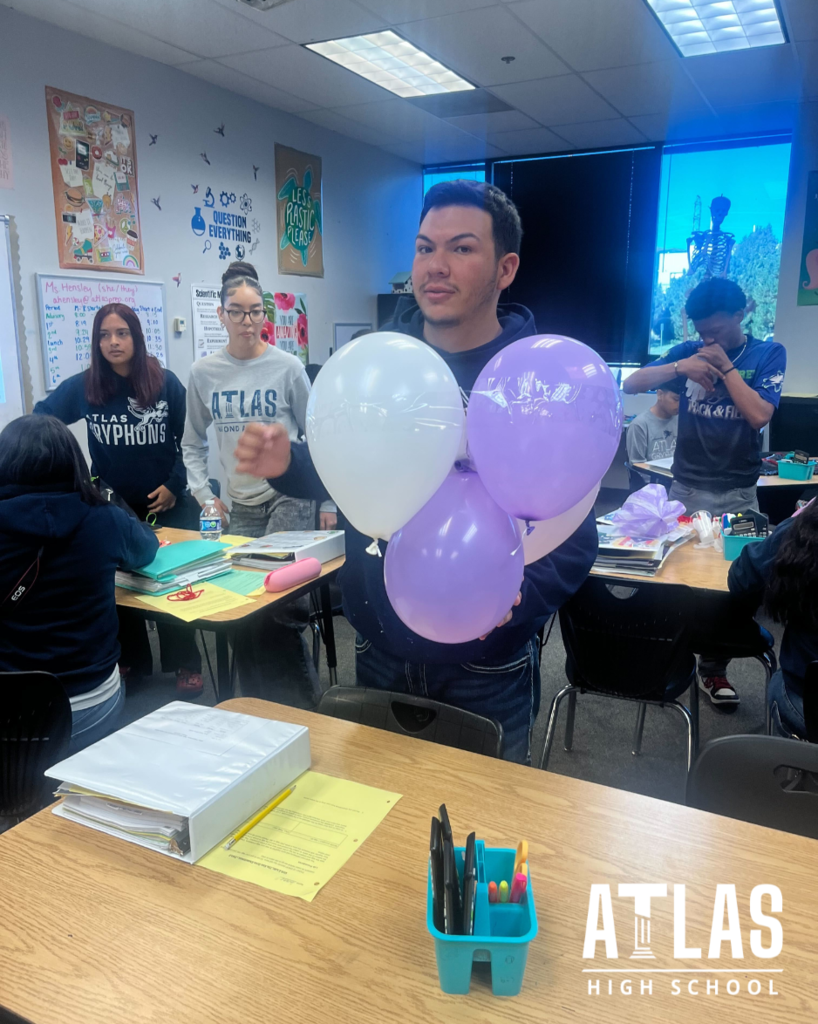 student holds balloons for egg drop