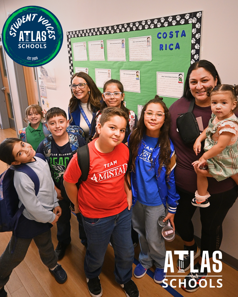 Atlas School logo with students and teachers standing in front of a bulletin bored.