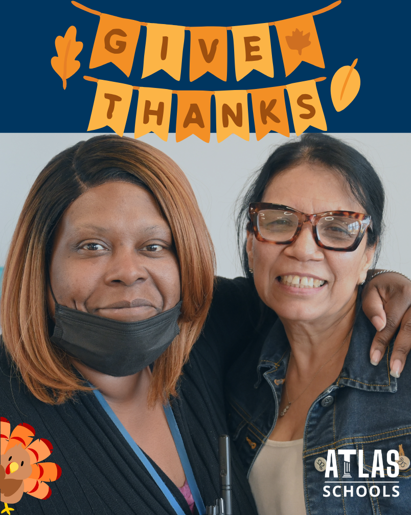Two women smile with give thanks over the top and a turkey peeking out from the bottom left corner.