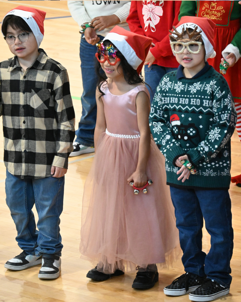 students smile while singing in holiday attire