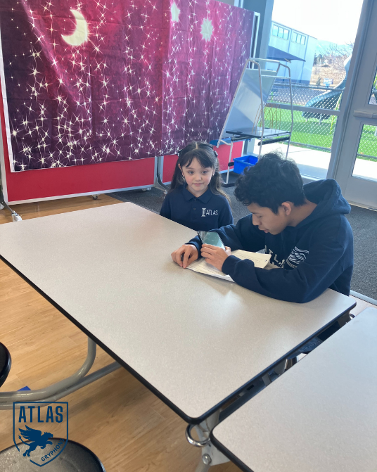 a high school student talks with an elementary student