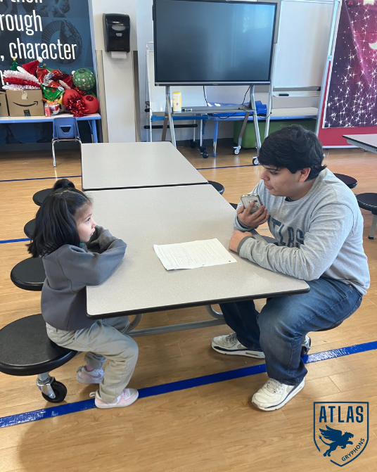 a high school student talks with an elementary student