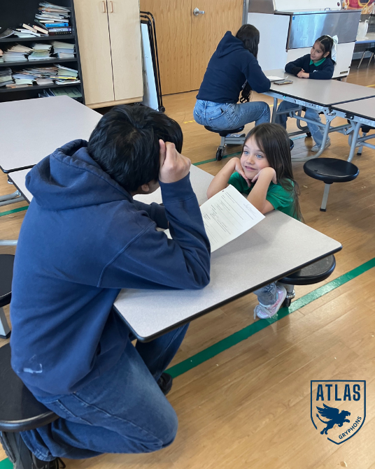 a high school student talks with an elementary student