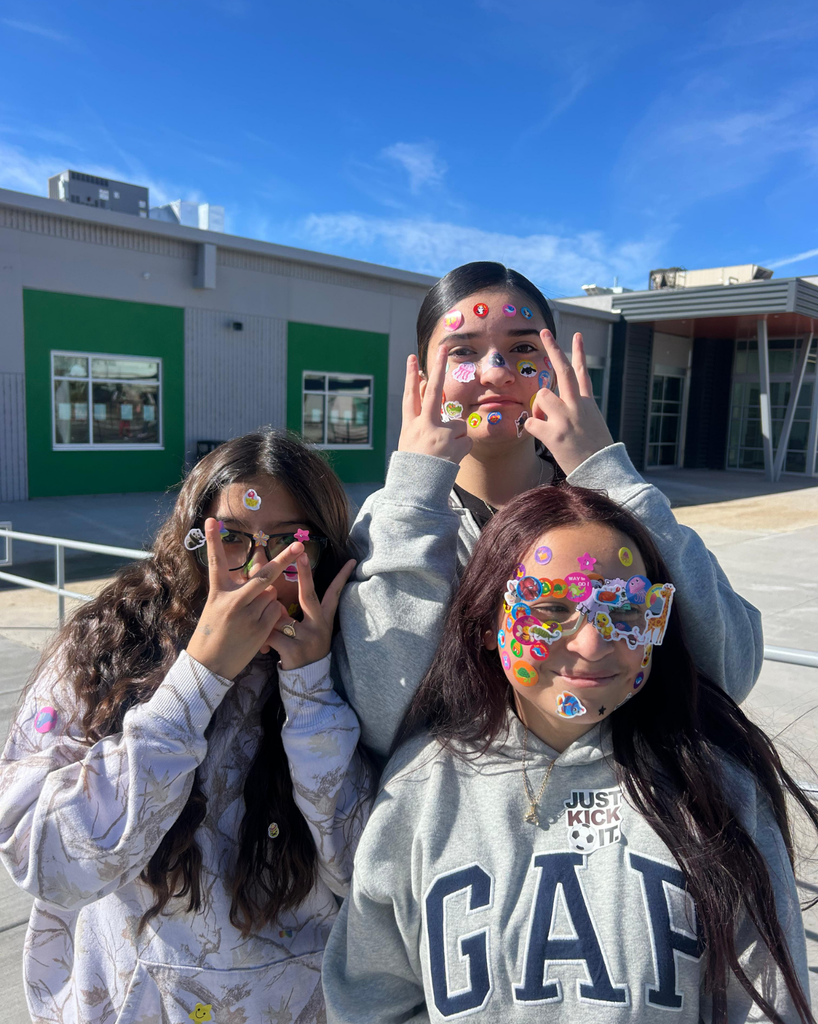 students smile with stickers on their faces