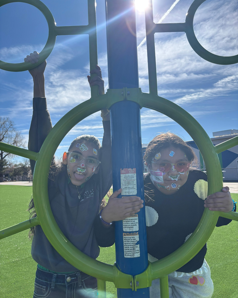 students smile with stickers on their faces