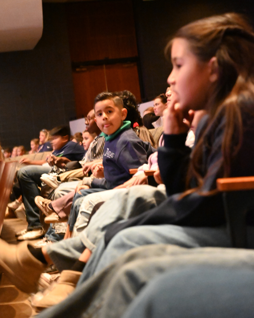 student smiles while watching performance