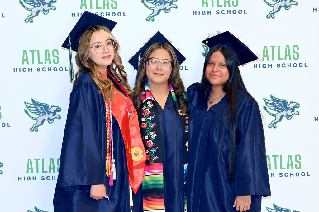 students smile in cap and gown