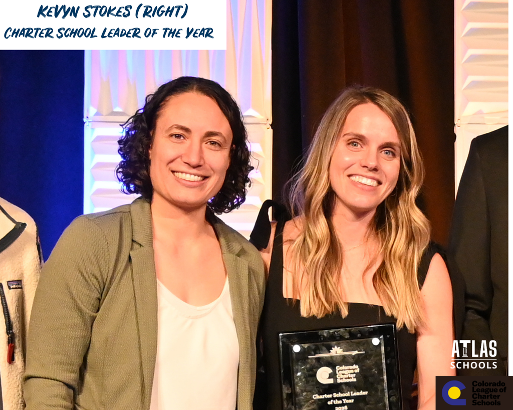 Two women smile, one with award