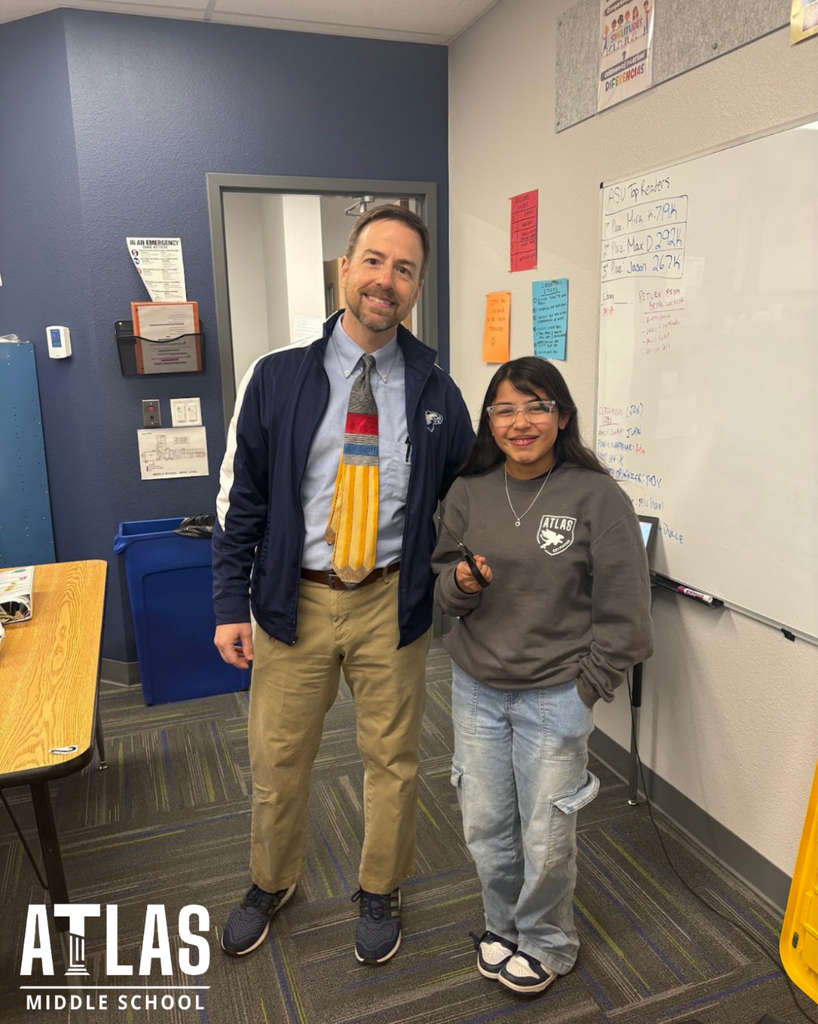 student smiles with scissors and principal with tie