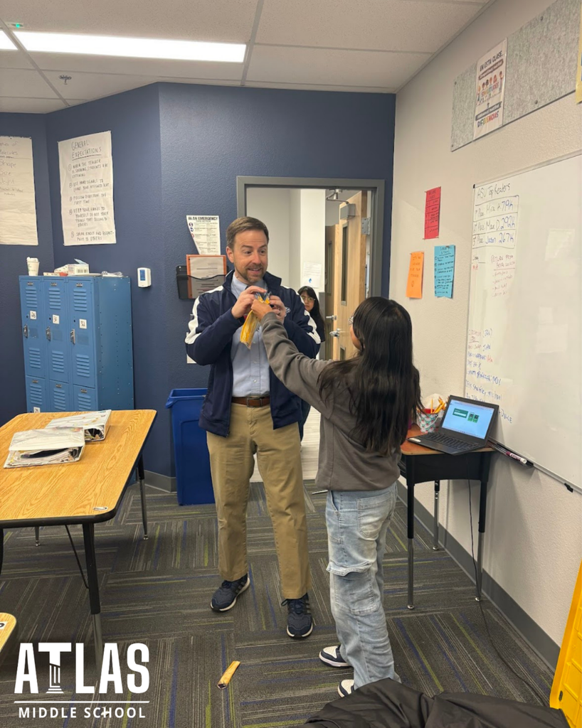 student smiles with scissors and principal with tie