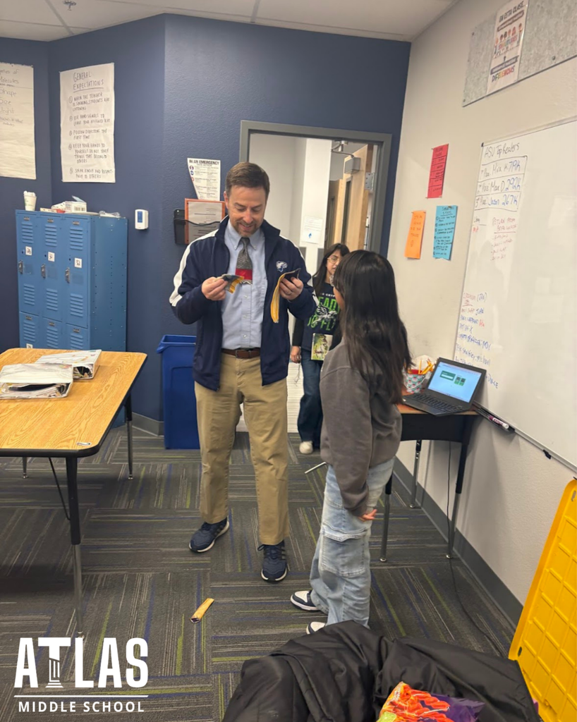 student smiles with scissors and principal with tie