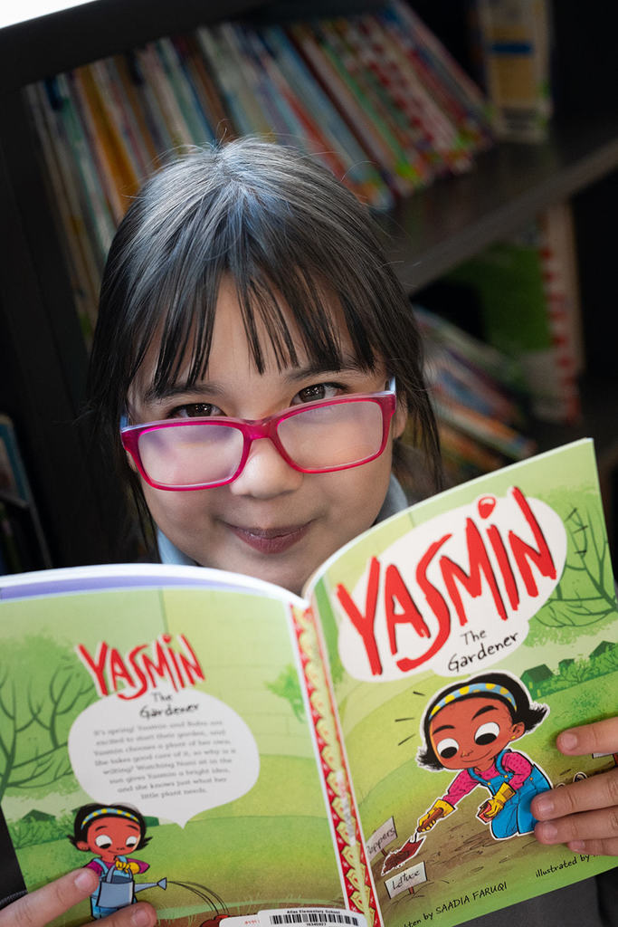 Girl smiles while reading a book