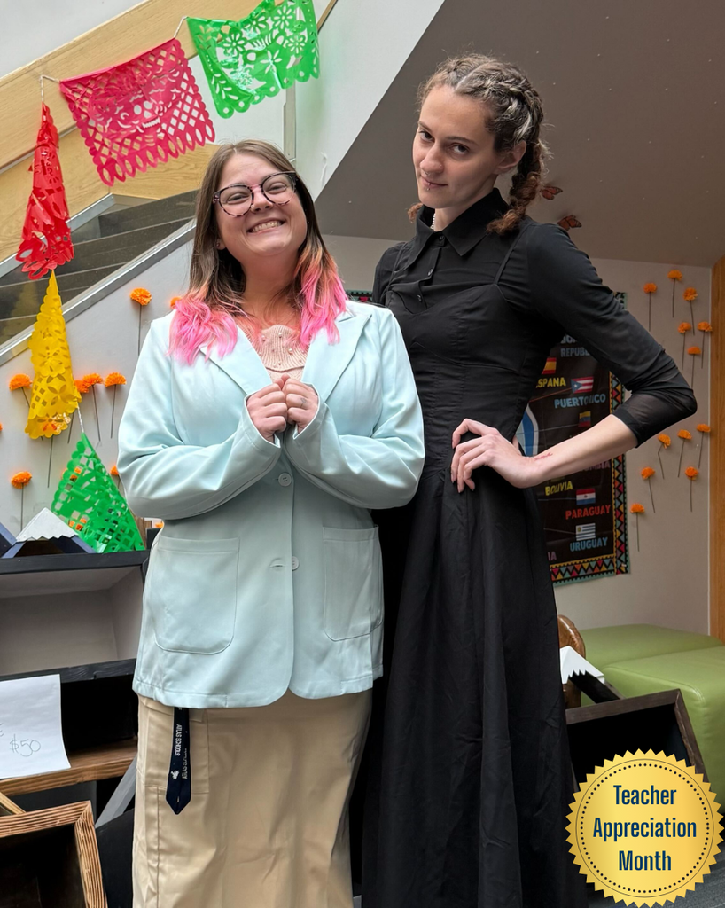 two teachers in costumes smile