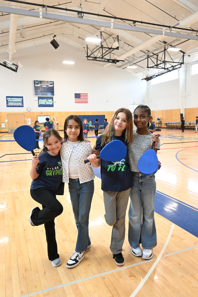 Students smile with pickel ball paddles