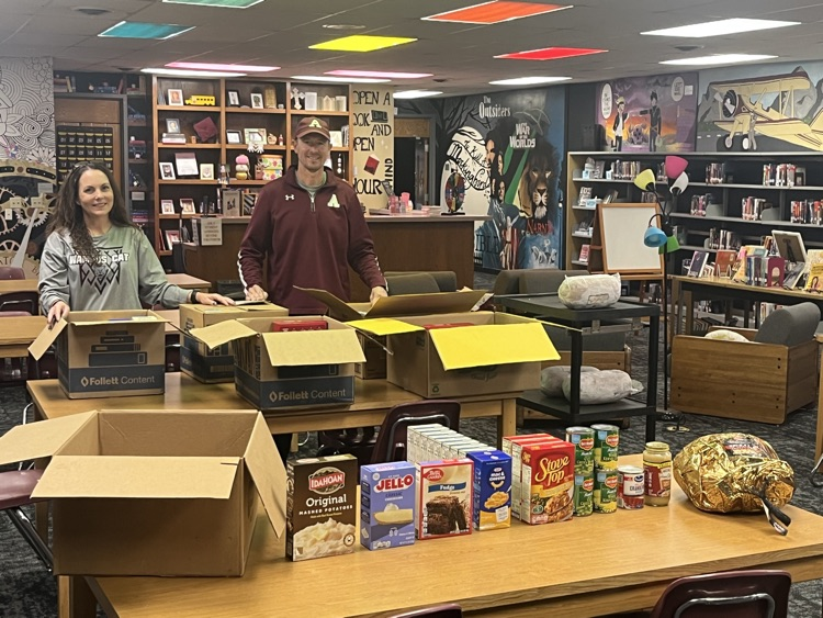 2 people in a library with a table of food