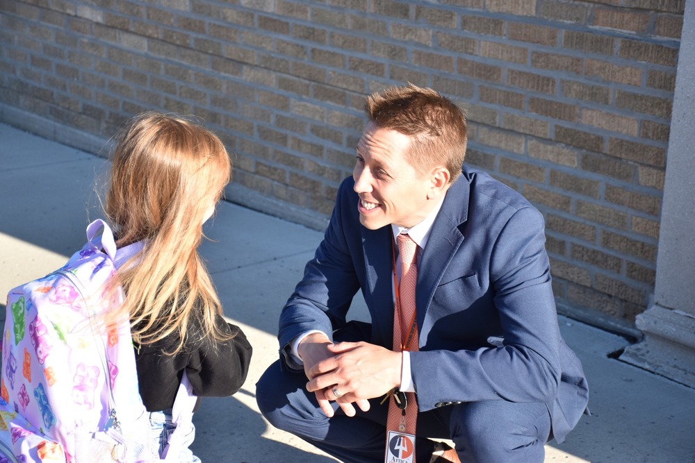Attica Superintendent Dr. Kiel Illg welcomes and elementary school student to the first day of school on Sept. 3.