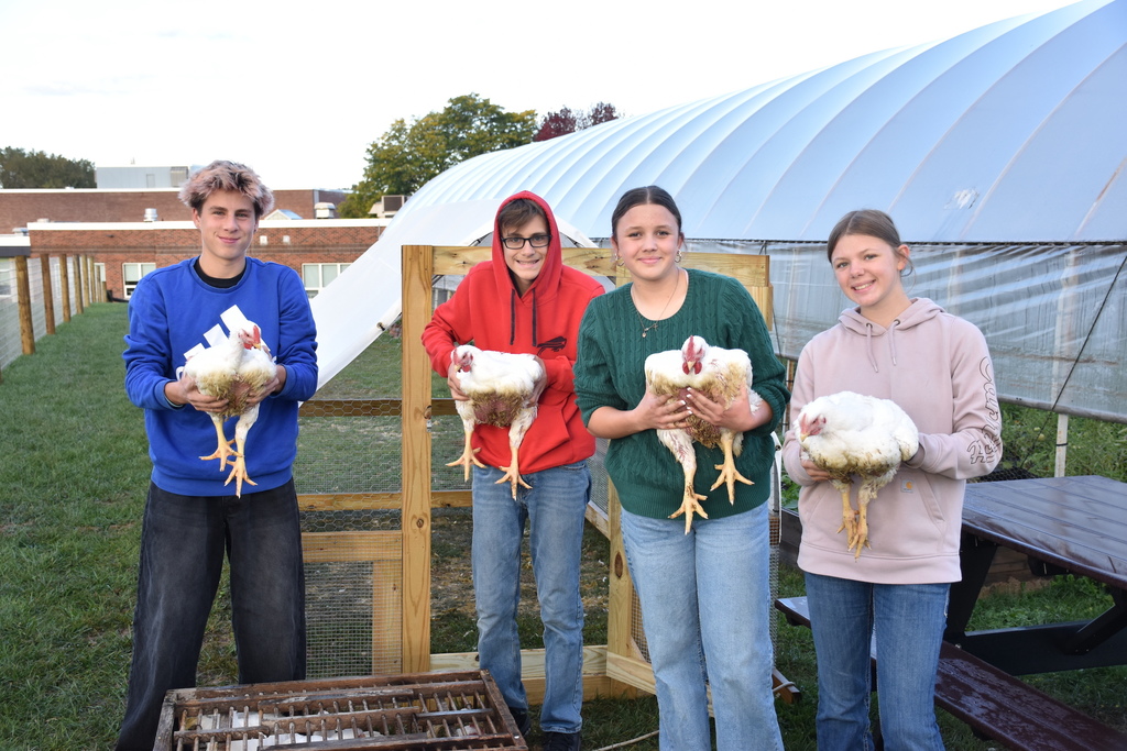 High school ag students are pictured holding meat birds.