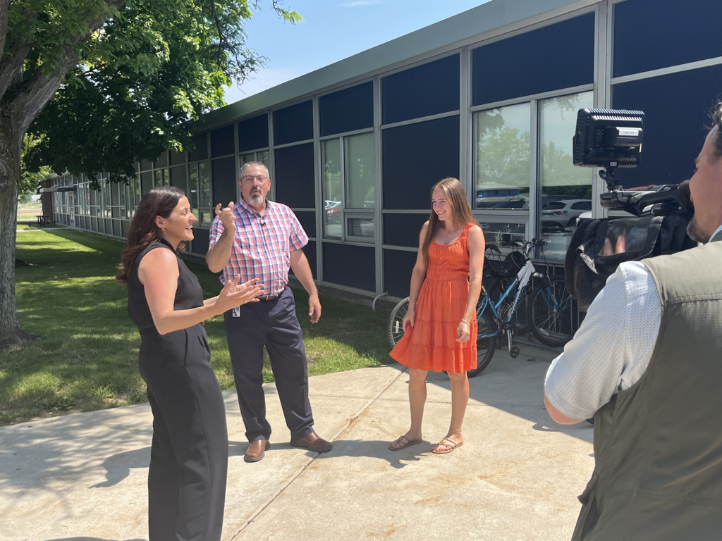 Rachel Rickettson and Mr. Jud Heck speak with a TV reporter Tuesday morning outside Attica High School.