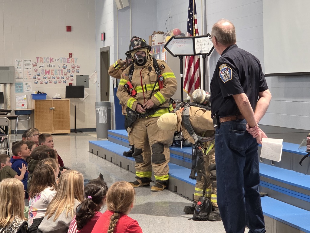 Firefighters demonstrating all the gear they put on to respond to a fire