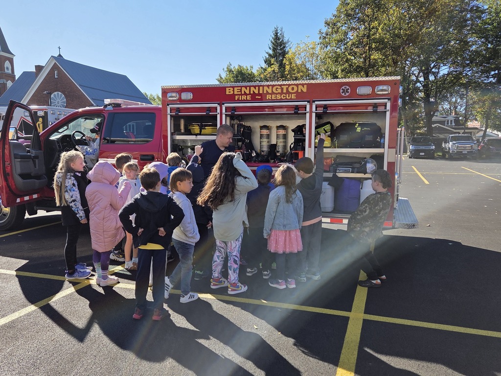 Firefighter teaching students about things they carry in their firetruck