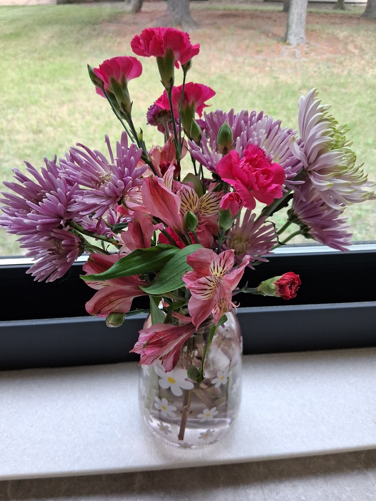 Picture of flowers in vase on windowsill.