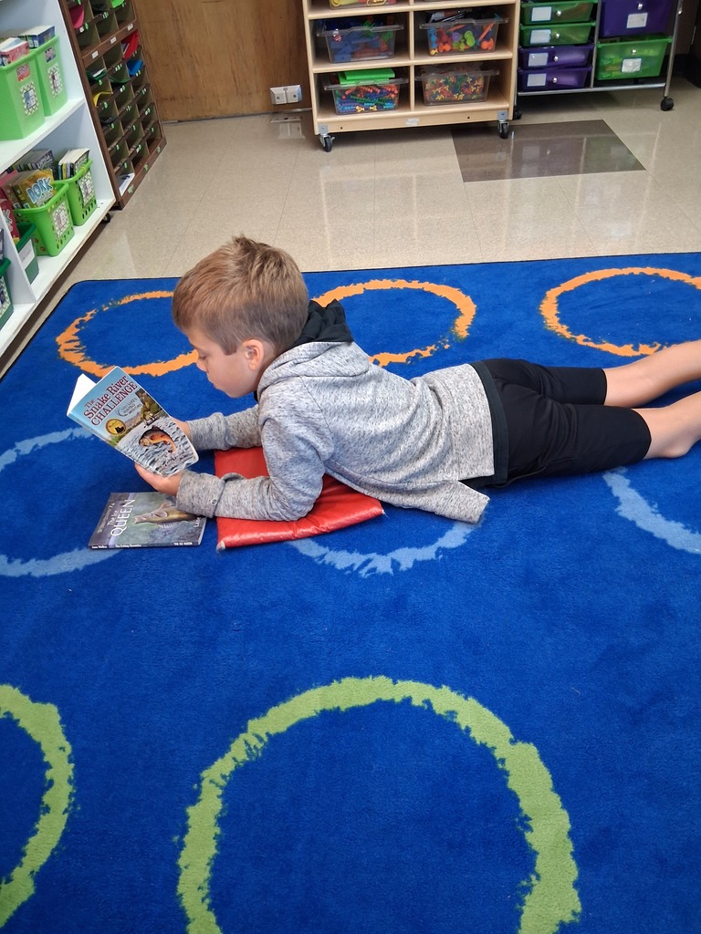 Student reading at the carpet
