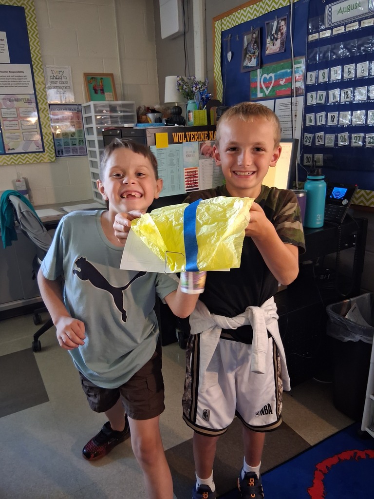 Students posing with their parachute designed to save Fred the gummy worm.