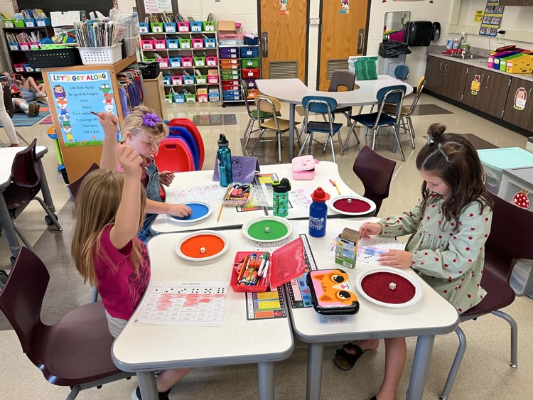 5 students doing a roll and read activity 