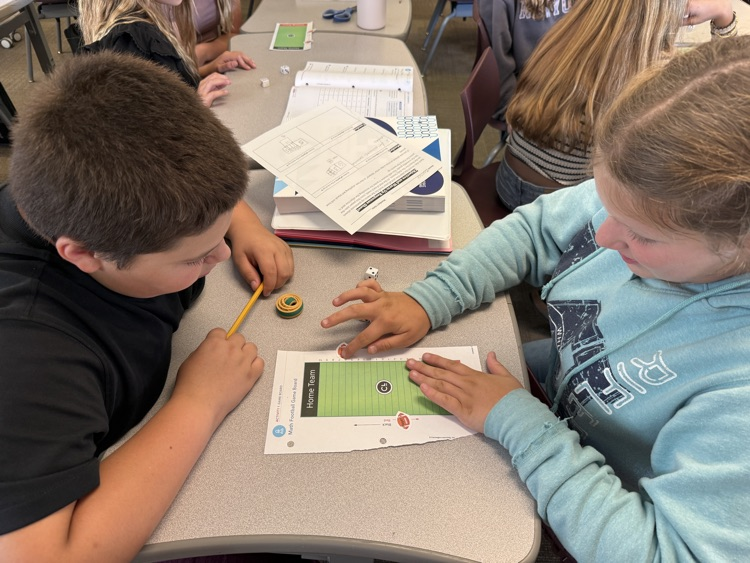 two students rolling dice and playing integer football