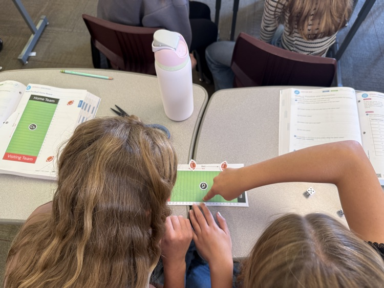 two students rolling dice and playing integer football