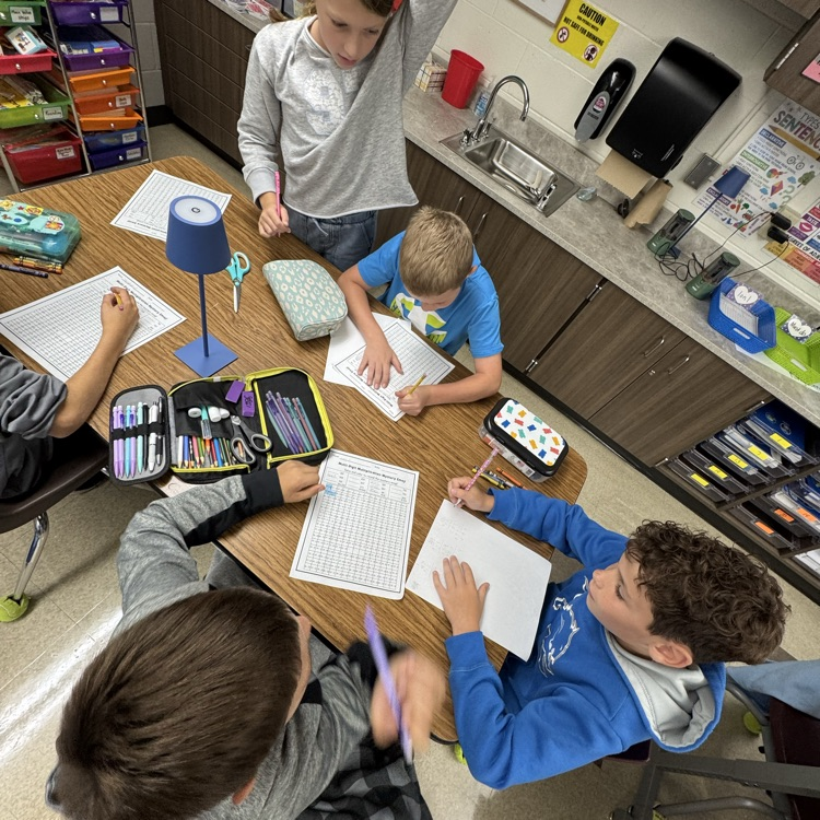 working together on a multiplication worksheet as a team.