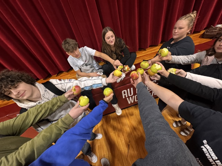 students holding and eating apples