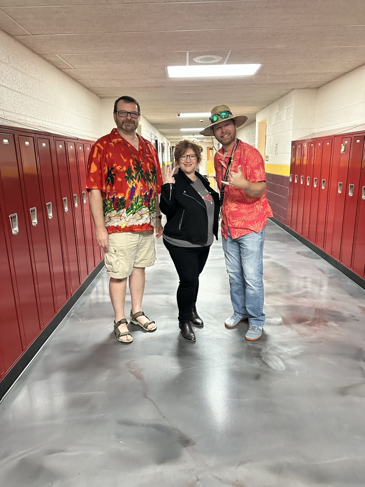 Two teachers dressed like surfers, one as a biker 