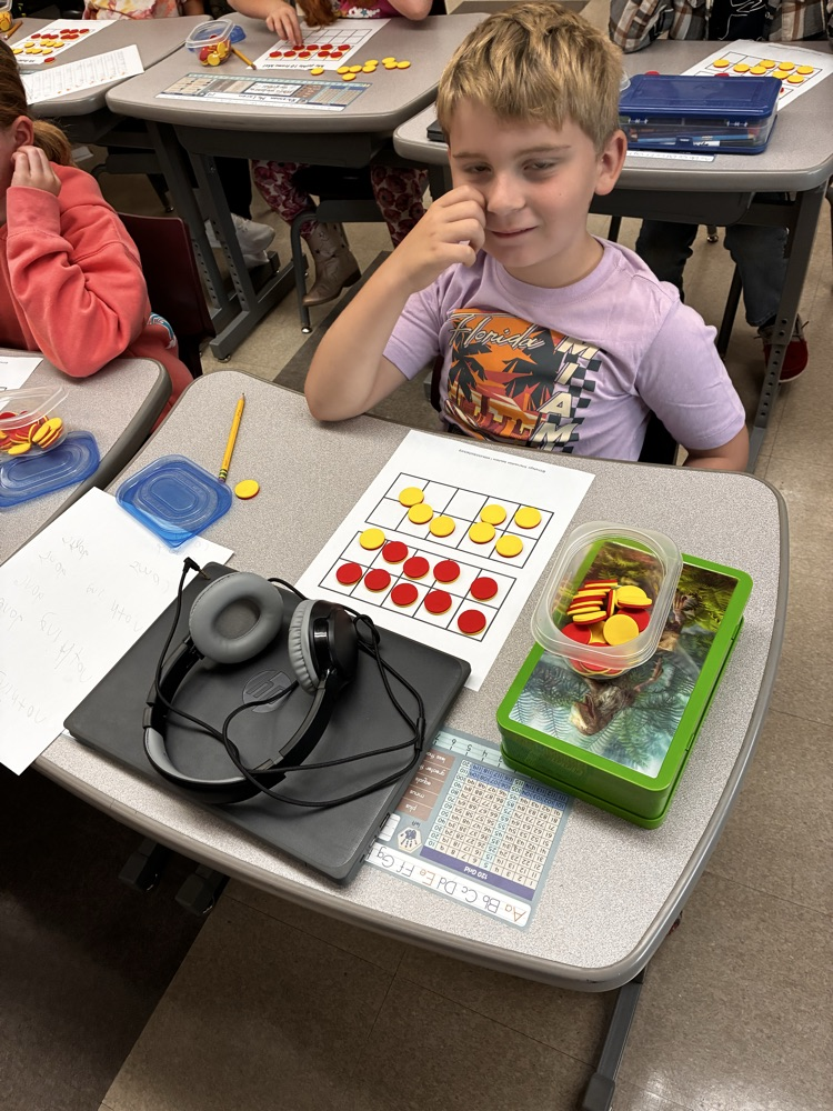Student work with math double sided math manipulative. 
